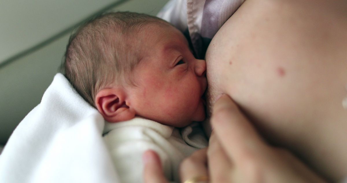 
Mother breastfeeding her newborn baby infant after birth for the first time